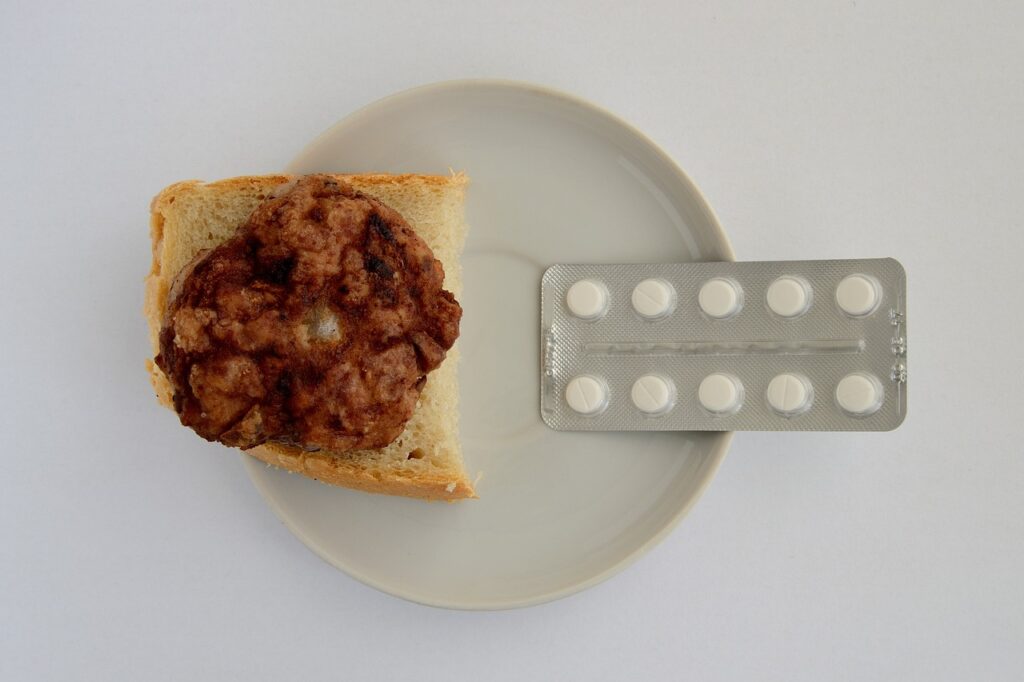 image shows a plate with food on it, and a strip of pills on the righthand side.